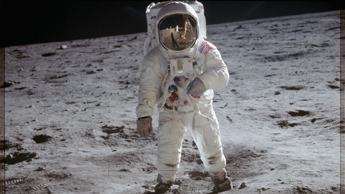 Apollo 11 astronaut Buzz Aldrin standing on the Moon in a white spacesuit.