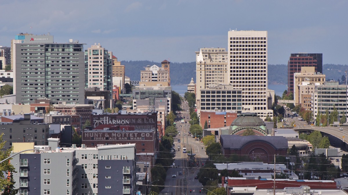 Downtown Tacoma, Washington, seen down Pacific Avenue, with office towers and Commencement Bay beyond.