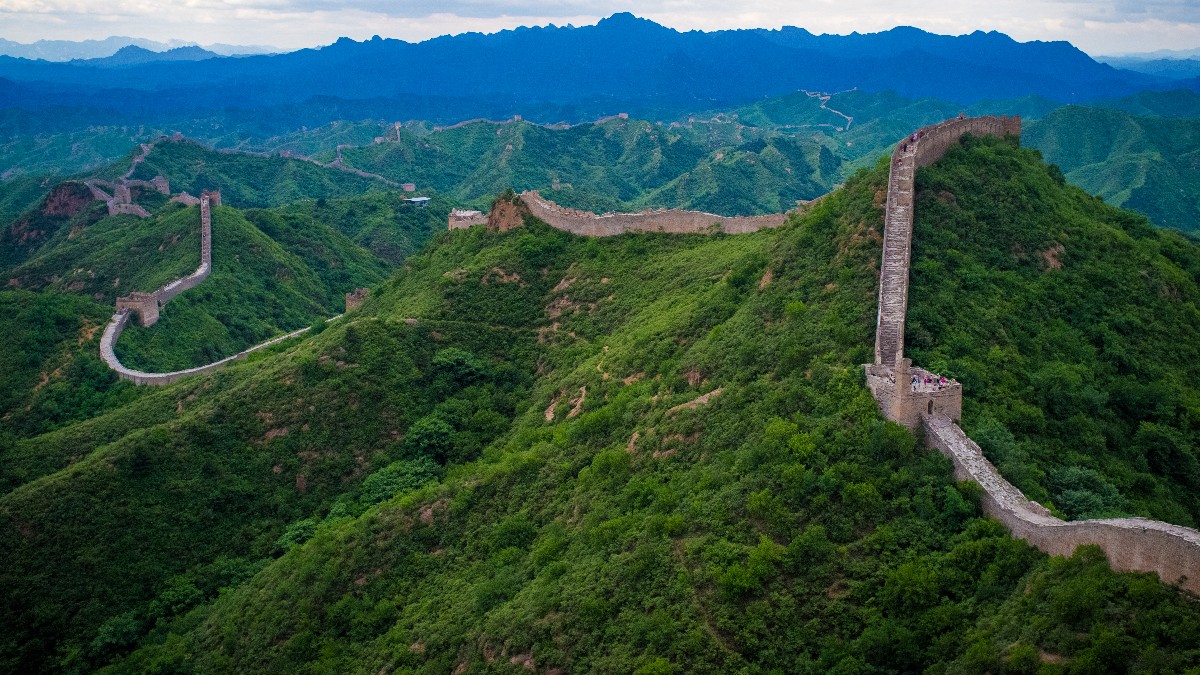 The Great Wall of China winding along forested mountain ridges at Jinshanling.
