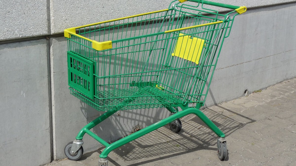 A metal grocery shopping cart standing on a store floor.
