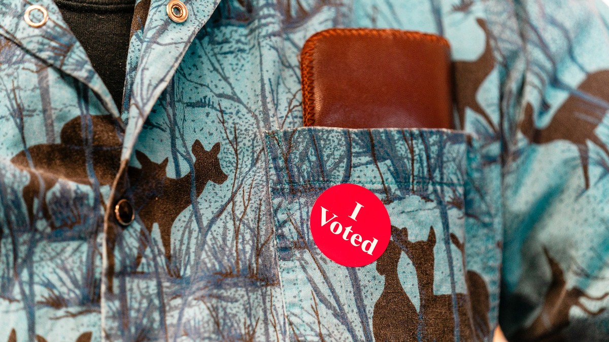 Close-up of a round 'I Voted' sticker on a voter's shirt.
