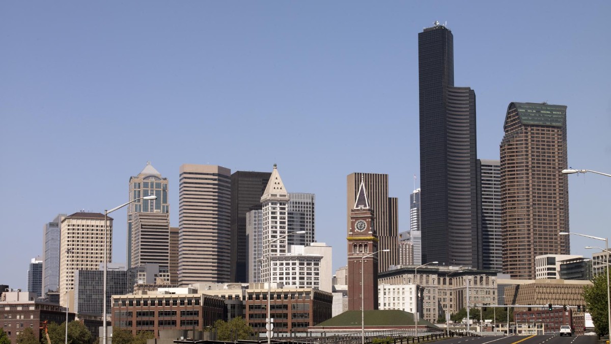 The downtown Seattle skyline of office towers seen from a distance under a clear sky.