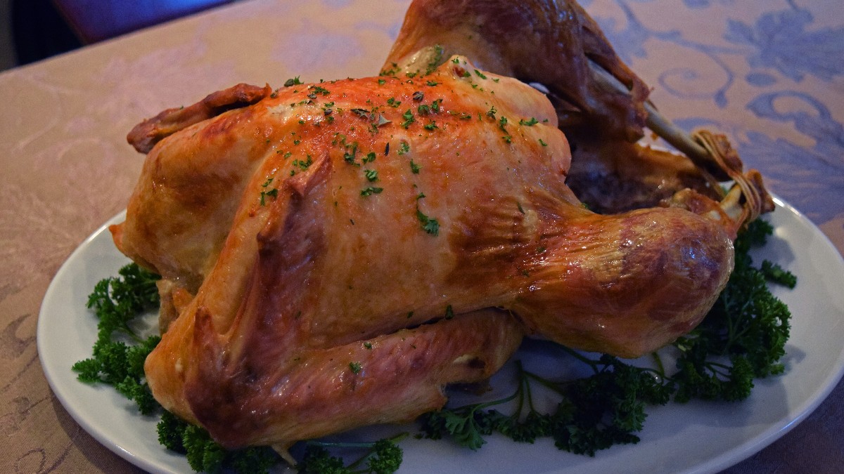 A whole roast turkey on a serving platter, served for Thanksgiving dinner.